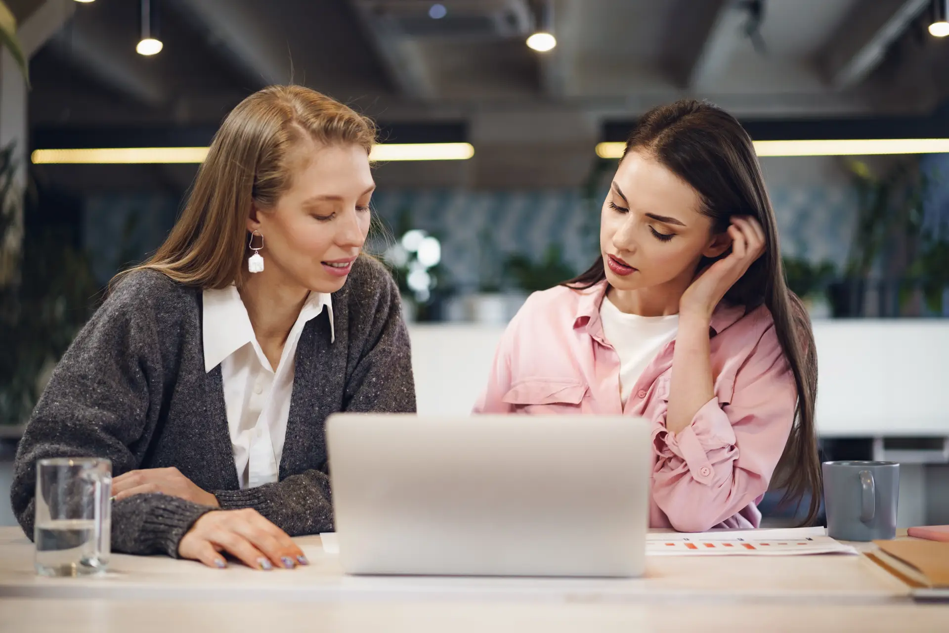 two-young-women-working-together-office.webp